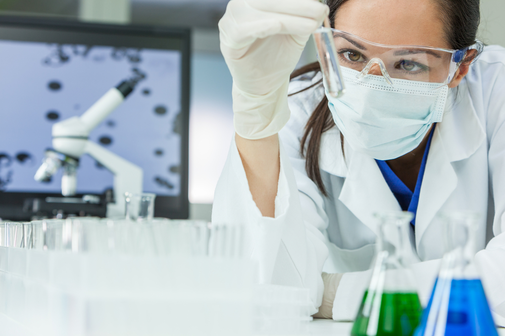 Female research scientist looking at a test tube, digital health